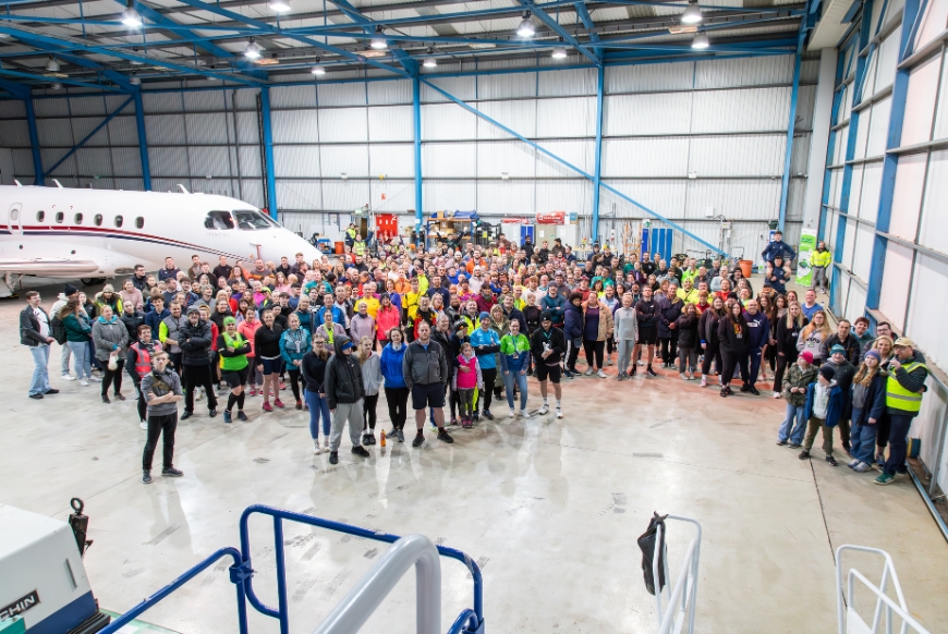 A group of runners in an airplane hanger at Bristol Airport